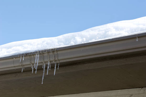 istock Icicles dripping over a snow covered rain gutter on a house 1135227563
