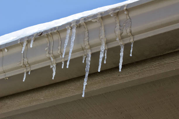 istock Icicles dripping over a snow covered rain gutter on a house 1135230269
