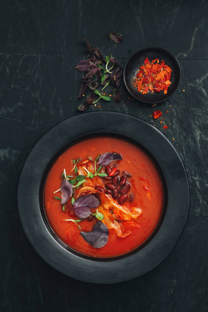 würzige tomaten, bohne, kräuter und gebratene specksuppe - tomato soup red basil table stock-fotos und bilder