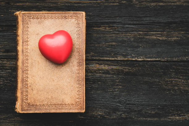 Heart shape on vintage book with copy space on wooden table