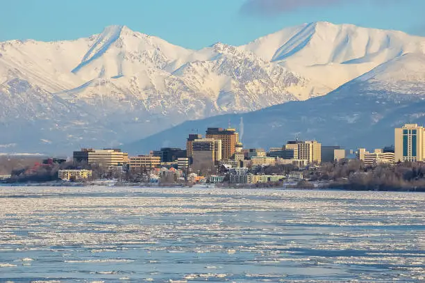 Downtown Anchorage, Alaska on the water with mountains in the background.