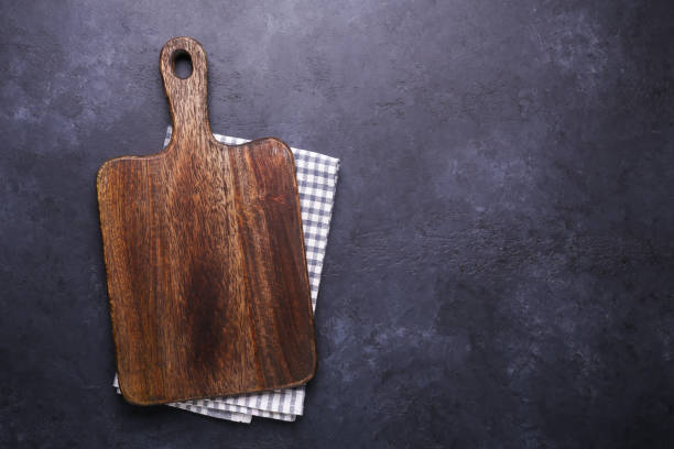 istock Dark stone table with cutting board and linen napkin Copy space 1135239341