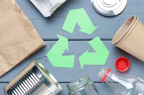 istock A Green recycle garbage symbol and plastic, iron garbage on a gray background, top view. 1135240445