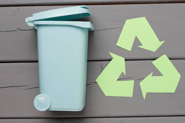 istock Green recycle garbage symbol and trash can on a gray background, top view. 1135240608