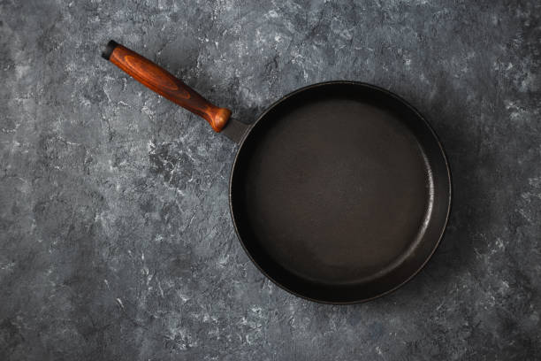 istock Empty round pan wooden handle dark stone background top view 1135249910