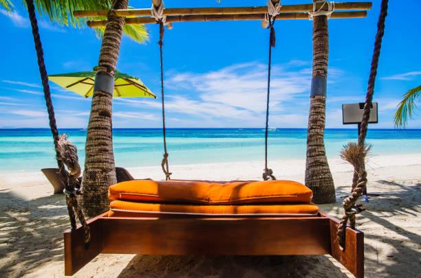 istock Hanging bed under palm trees on tropical beach 1135249966