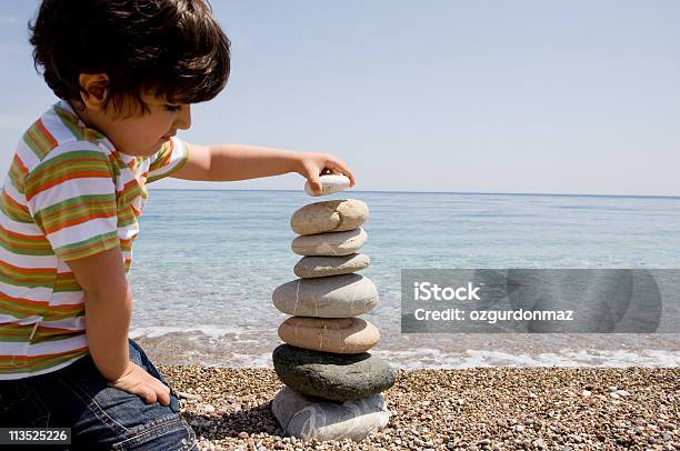 Boy Stacking Rocks Stock Photo - Download Image Now - Child, Stacking, Rock - Object