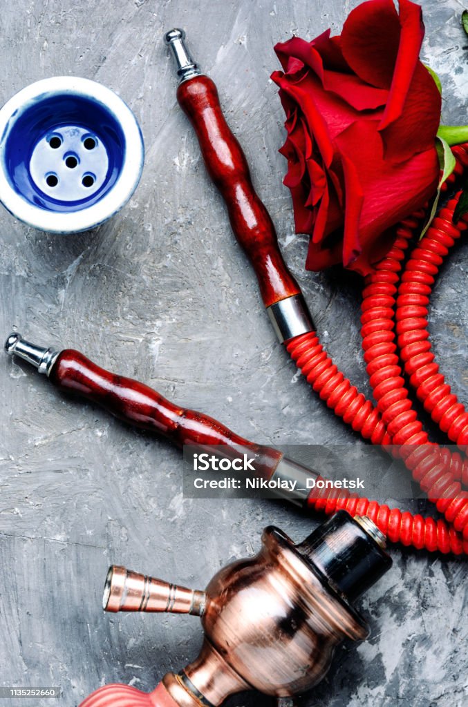 Smoking hookah with rose flavor East hookah with flower aroma for relax.Shisha hookah.Smoking a hookah Addiction Stock Photo