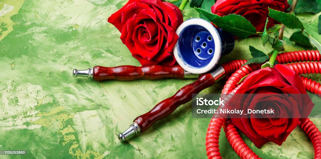 Smoking hookah with rose flavor East hookah with flower aroma for relax.Shisha hookah.Smoking a hookah Addiction Stock Photo