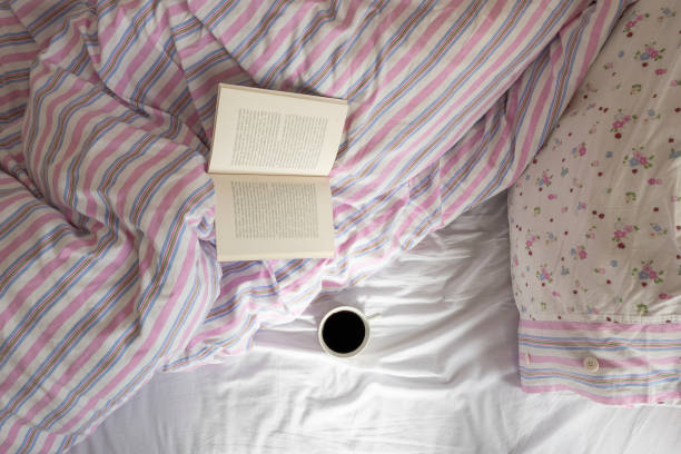 istock Morning coffee and book on the bed 1135252899