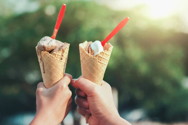 istock hand holding ice cream cone in morning light 1135253816