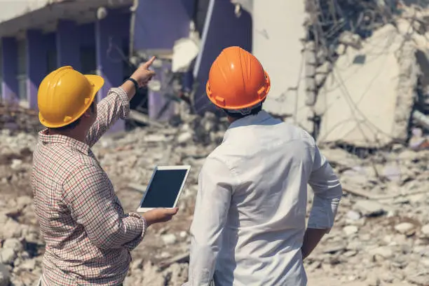 Photo of Engineer architect and worker operation control demolish old building.