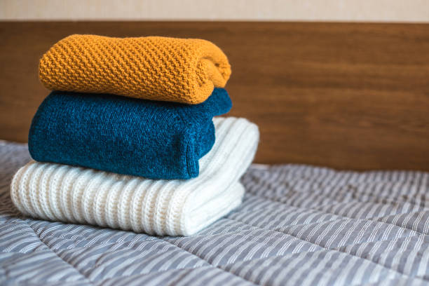istock Pile of cozy knitted sweaters on bed. 1135258603