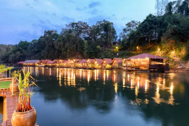 Tropical wooden raft resort illumination on river kwai at dawn. Sai Yok Yai, Kanchanaburi