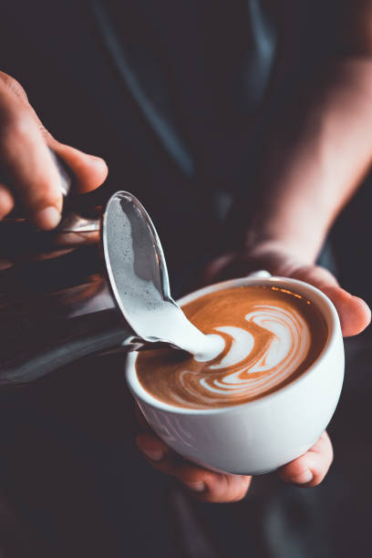 tono vintage di alcune persone versare latte per fare latte art caffè al bar o coffe shop - morning cream food milk foto e immagini stock