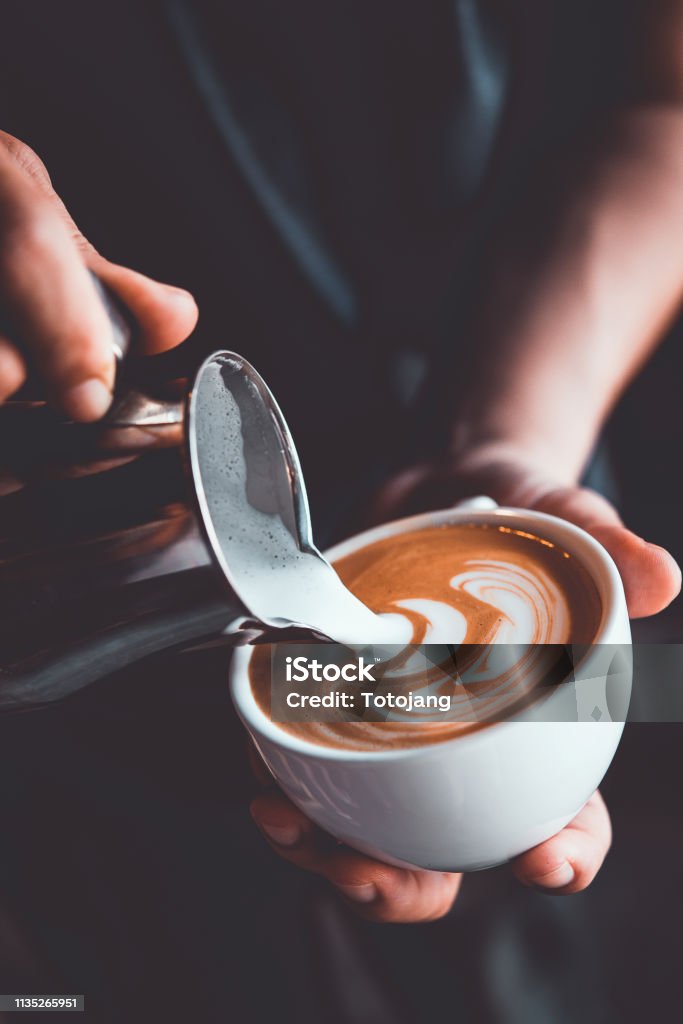vintage tone of some people pour milk to making latte art coffee at cafe or coffe shop Coffee - Drink Stock Photo