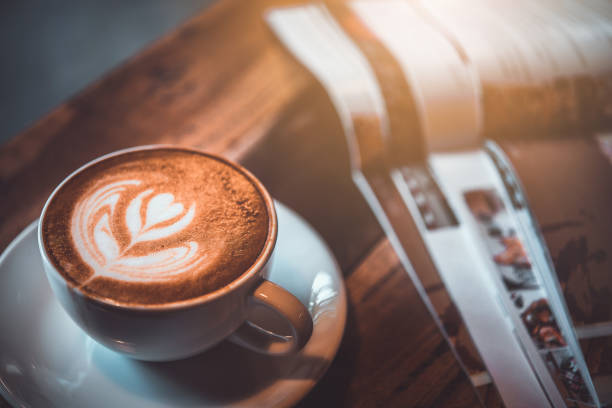 taza de latte en la mesa con la revista en la cafetería. - espresso coffee cream coffee shop fotografías e imágenes de stock