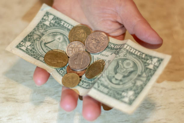 istock Various random cash dollar bills and american coins scattered. 1135267356