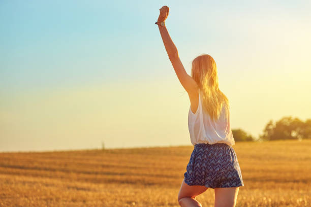 istock Cute young woman jumping in a wheat field. 1135268465