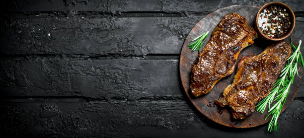 istock Grilled beef steaks with spices and herbs. 1135269894
