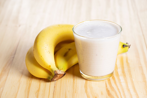 Banana smoothie on wooden table. Heathy smoothie.