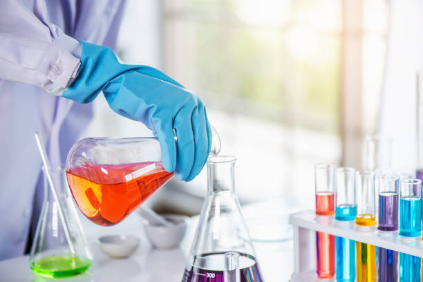 istock Scientist holding sampling oil or chemical liquid in flask with lab glassware in laboratory background. 1135270290
