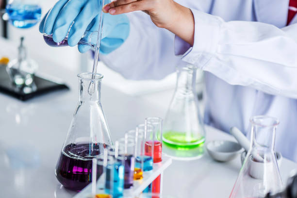 istock Scientist holding sampling oil or chemical liquid in flask with lab glassware in laboratory background. 1135270294
