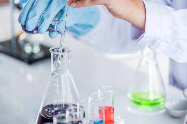 istock Scientist holding sampling oil or chemical liquid in flask with lab glassware in laboratory background. 1135270295