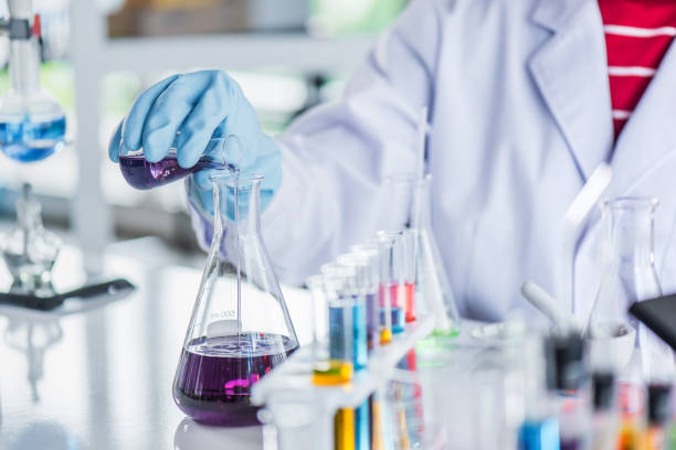 istock Scientist holding sampling oil or chemical liquid in flask with lab glassware in laboratory background. 1135270296