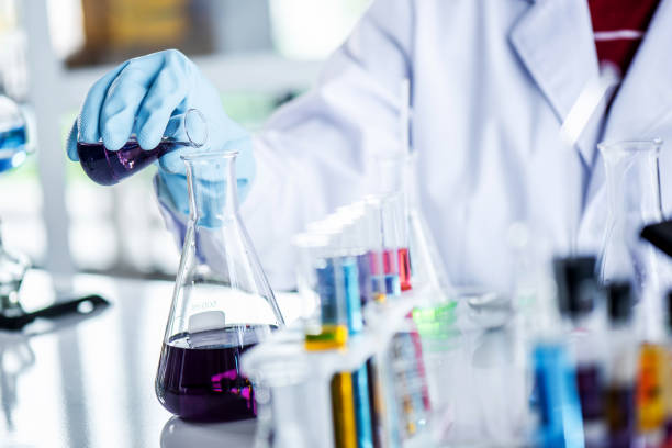 istock Scientist holding sampling oil or chemical liquid in flask with lab glassware in laboratory background. 1135270298