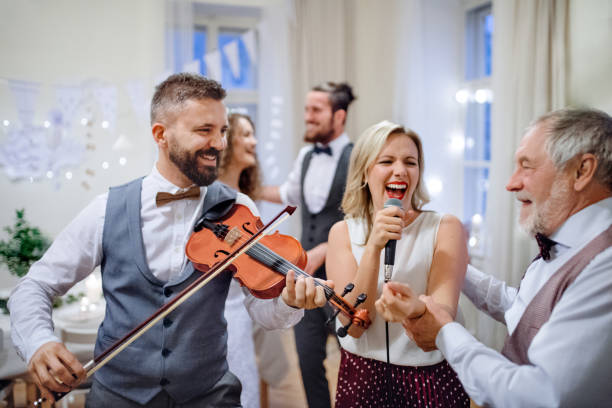 istock A young bride, groom and other guests dancing and singing on a wedding reception. 1135270580