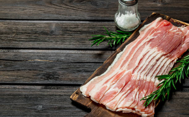 istock Raw bacon with rosemary and spices. 1135271289