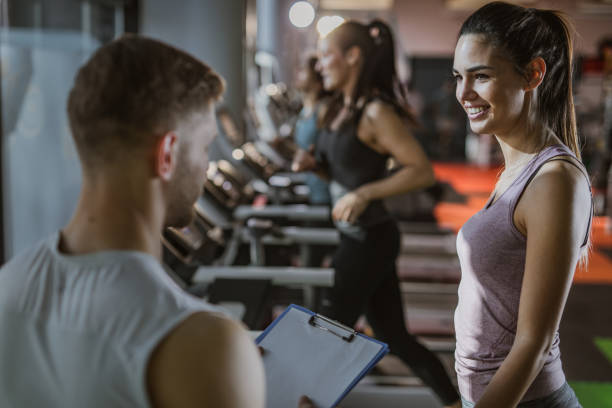 istock Happy athletic woman talking to her instructor while exercising on treadmill in a gym. 1135271323