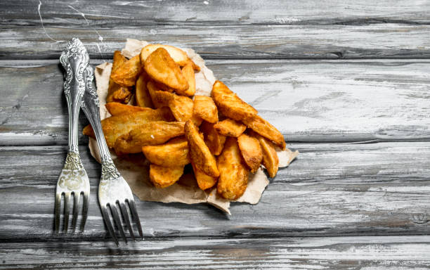istock Baked potato wedges on the paper. 1135271396