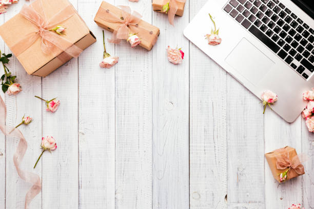 istock Workspace with a laptop keyboard, rose flowers, gift boxes 1135271425