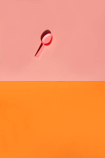 istock Pink plastic spoon on pink and orange background. 1135274423
