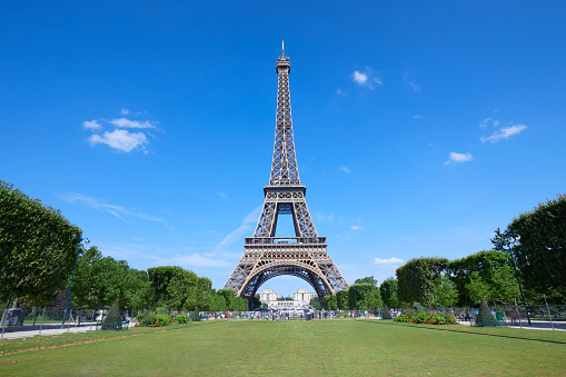 Eiffel Tower in Paris and empty green field of Mars meadow in a sunny summer day, clear blue sky