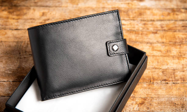 Black leather wallet on a wooden table