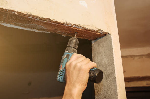 istock Man in using electric drill for doors. Maintenance repair works renovation in the flat. Restoration indoors. Concrete background. 1135278532