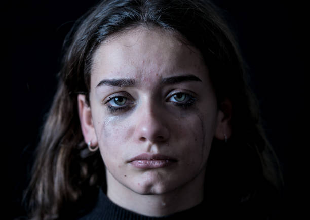 istock Scared upset girl bullied online suffering harassment crying feeling desperate and intimidated. Child victim of cyberbullying, stalker, social media and dangers of the Internet. Dramatic dark light. 1135278837
