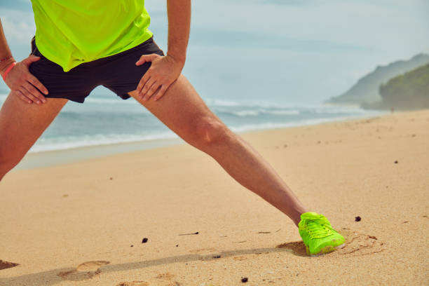 istock Sportsman stretching on a tropical sandy beach. 1135279428