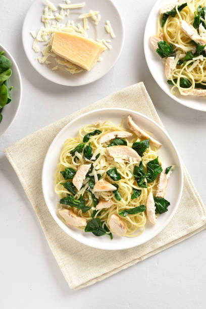 istock Spaghetti with spinach leaves, slices grilled chicken breast and grated cheese 1135279496