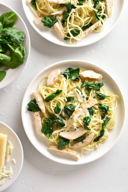istock Spaghetti with spinach leaves, slices grilled chicken breast and grated cheese 1135279502