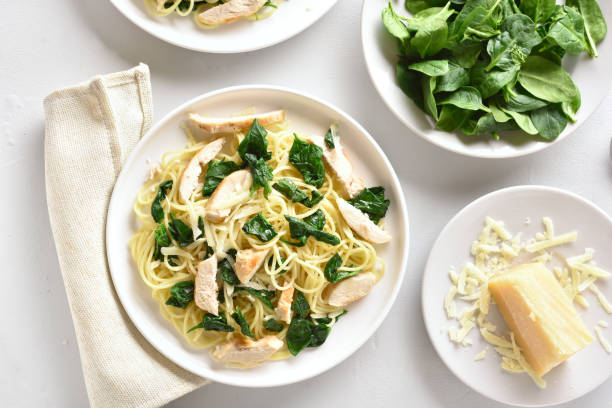 istock Spaghetti with spinach leaves, slices grilled chicken breast and grated cheese 1135279517