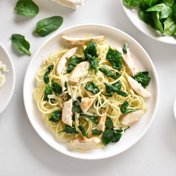 istock Spaghetti with spinach leaves, slices grilled chicken breast and grated cheese 1135279523