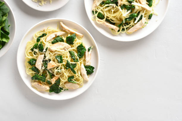 istock Spaghetti with spinach leaves, slices grilled chicken breast and grated cheese 1135279533