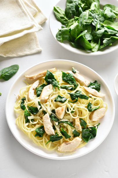 istock Spaghetti with spinach leaves, slices grilled chicken breast and grated cheese 1135279538