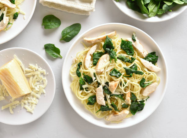 espaguetis con hojas de espinacas, rodajas de pechuga de pollo asada y queso rallado - parmesan cheese pasta italian culture food fotografías e imágenes de stock