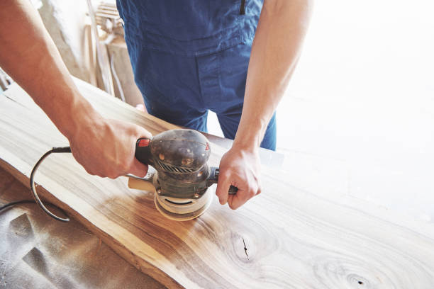 istock a young carpenter and a mask polishes a wooden rack in the studio. 1135280497