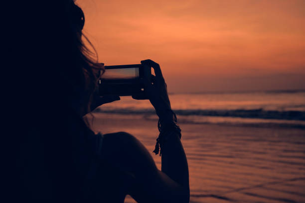 istock Woman using cellphone on a tropical ocean beach. 1135281843